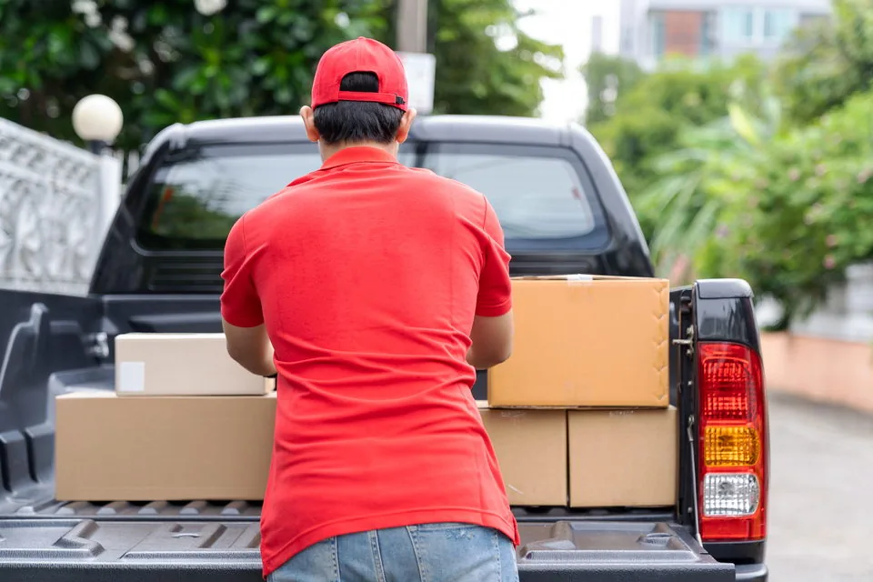 Operador cargando cajas en la palangana de su pickup